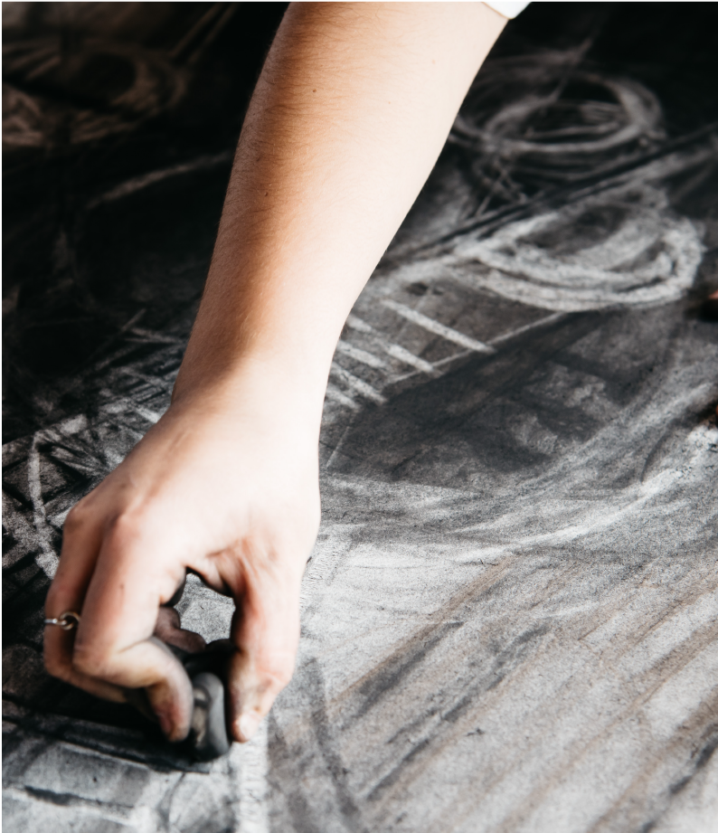 Hand drawing a charcoal piece of artwork